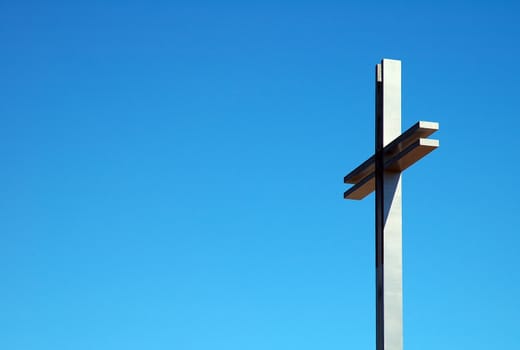 detail photo of a steel cross, blue sky, 