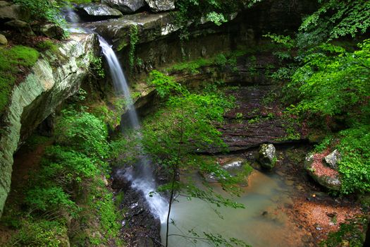 Waterfall flows into a deep canyon in the woodland of northern Alabama.