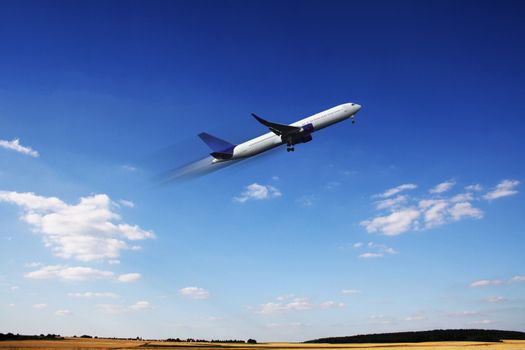 Aircraft in flight over the blue clouds 