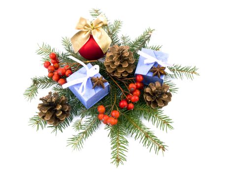 Christmas composition made from red glass ball, rowan, spruce, lilac giftboxes and cones on white background