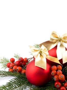 Red glass balls with nice golden ribbons, rowan and fresh spruce on white background