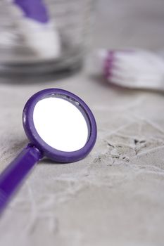 Purple dental mirror on the brown countertop.