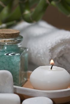 Spa background with bath salts, towels and candles on a bamboo mat.