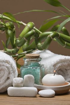 Spa background with bath salts, towels and candles on a bamboo mat.