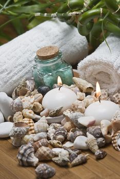 Spa background with bath salts, towels and candles on a bamboo mat.