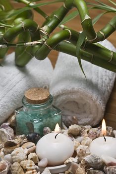 Spa background with bath salts, towels and candles on a bamboo mat.