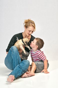 Cute little boy kissing his new pet Pug