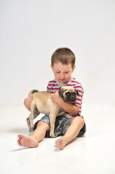 Baby boy with his new pet Pug, getting to know each other.
