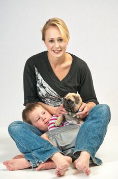 Young woman with her son getting to know the new Pug they rescued from the animal shelter.