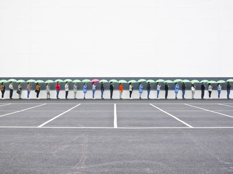 People with umbrellas waiting in line