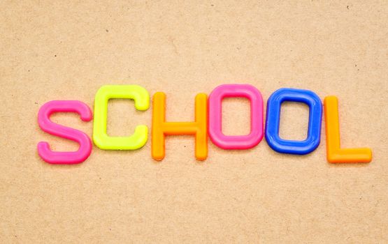 School in colorful toy letters on paper background