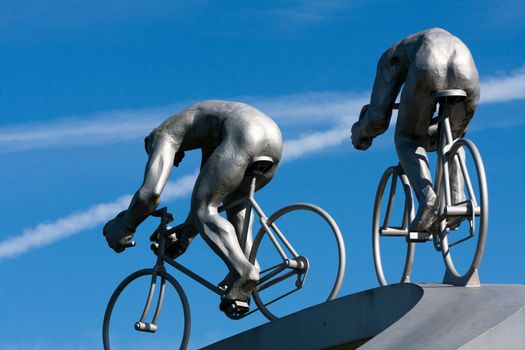 Two cyclists and their muscles, back, sculpture