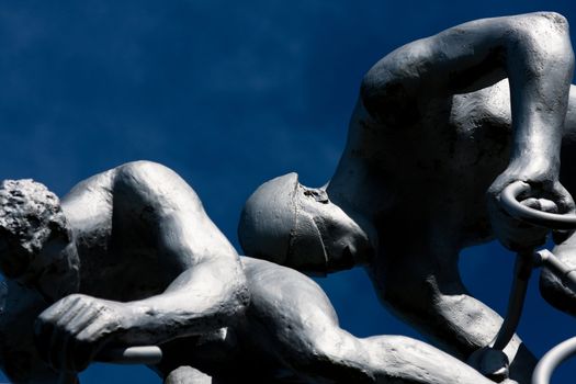 Detail of a sculpture of two cyclists and their muscles