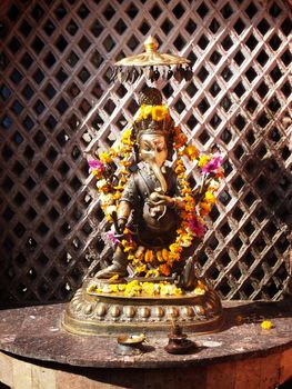 Hindu altar with candles and african marigolds for worshipping Lord Ganesh.