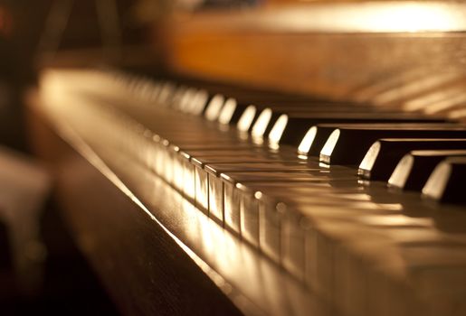 Closeup of black and white piano keys and wood grain with sepia tone