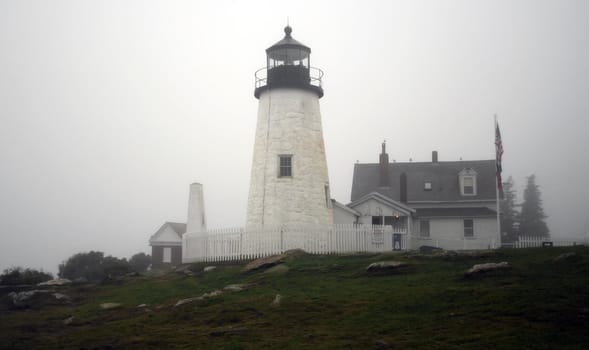 A lighthouse sitting in light fog in Maine, USA