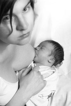 black and white picture: mother breast feed newborn child