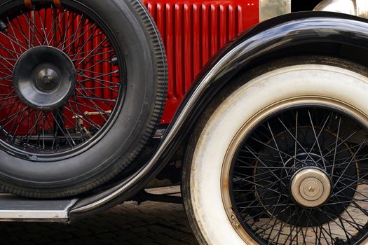 The fender and spoked wheels of an antique classic car.
