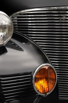 The chrome grill and headlights of an antique classic car.