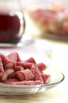 candy in the sugar on a plate with tea cup blurry background