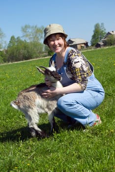 The Girl-farmer and young goat.Rural scene