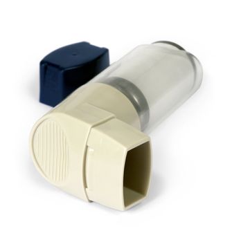 Isolated image of an asthma inhaler / puffer.  Shallow depth of field - focus on the mouthpiece.
