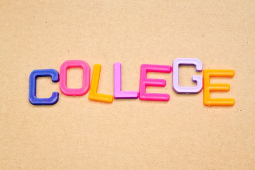 College in colorful toy letters on paper background
