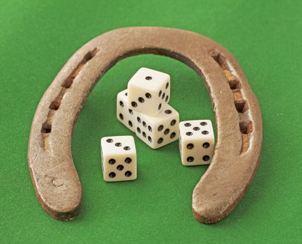 Jorseshoe and dice, over green background