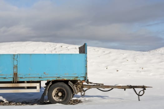 Blue trailer parked in a snowy field