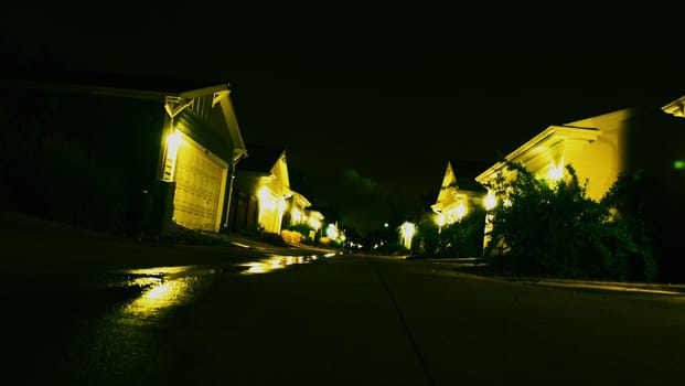 Night time in a suburban ally lined with garages.