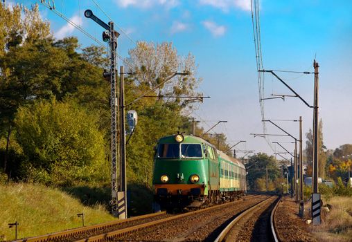 Passenger train near the semaphore in the autumn scenery
