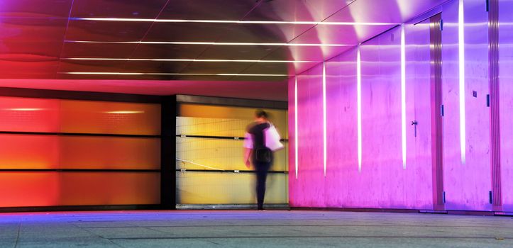 multi colored underground tunnel with people in morion