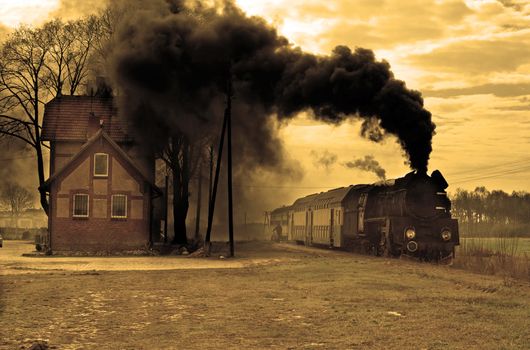 Old retro steam train stopped at the small station
