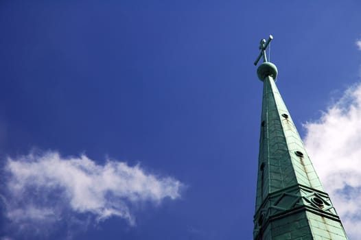 detail photo of copper church roof, cross, blue sky