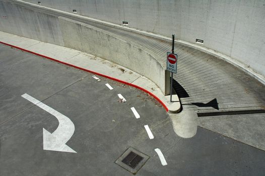 concrete and asphalt crossroad, no access sign, white arrow
