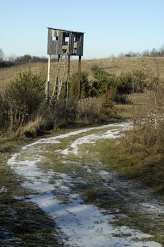 wooden hunting lookout, winter time, snow, dry grass