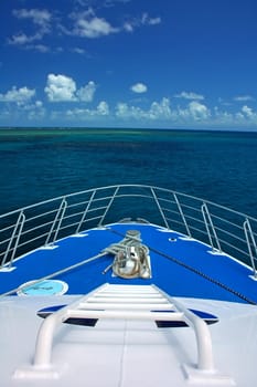 boat travelling to coral reef, blue sky with clouds