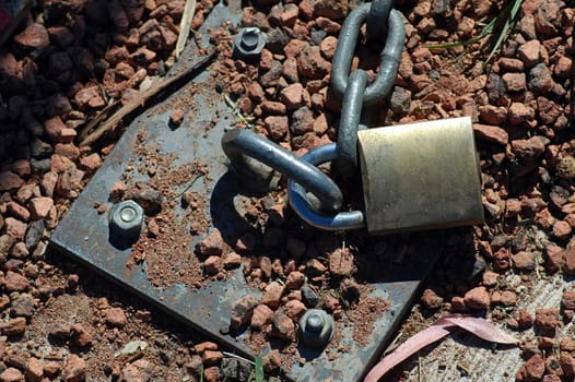 steel chain locked into gravel ground, hot weather