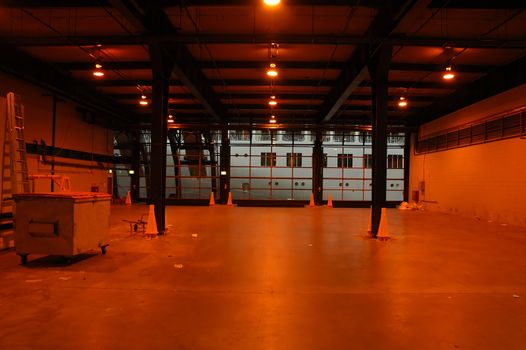 empty red warehouse, part of a big white ship in background