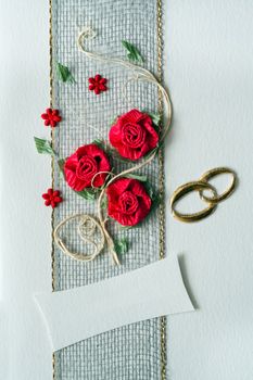 Wedding invitation ornament with red roses and rings
