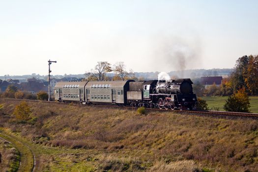 Old retro steam train passing through polish countryside
