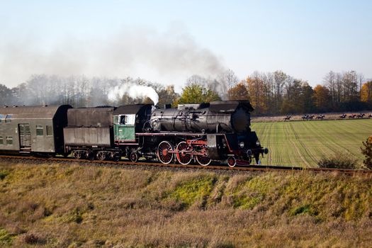 Old retro steam train passing through polish countryside
