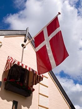 Flag of Denmark Danish on a house with blue sky background