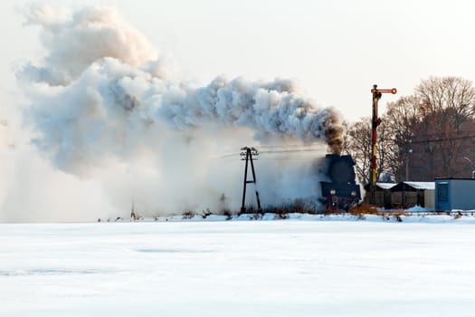 Vintage steam train starting from the station, wintertime
