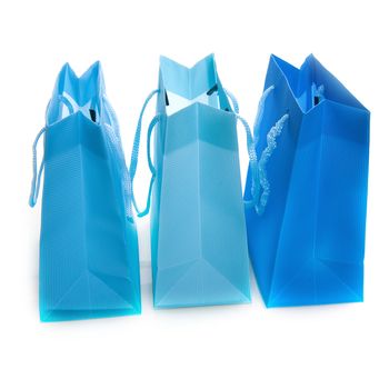 three different colored blue bags on white
