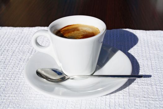 Small cup of espresso with a spoon.