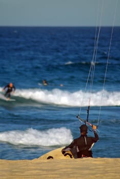 Kite surfer going into water, blurred surfers in background, photo taken in Sydney, 