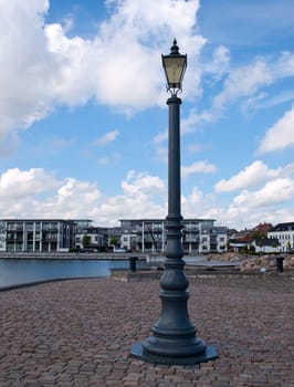 Classical retro style street lamp on a metal pole in a city water front area