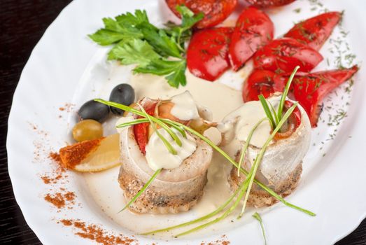 fillet of pikeperch stuffed with trout fish with baked pepper, tomato and leek