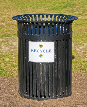 An outside garbage can with a recycle sign